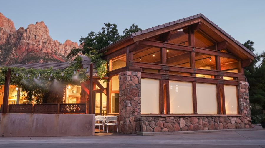 Property exterior at dusk with red rock cliffs behind
